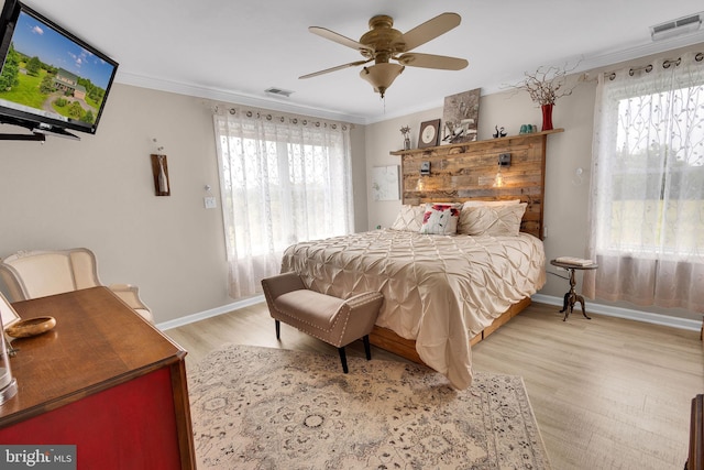 bedroom with ceiling fan, light wood-type flooring, and ornamental molding