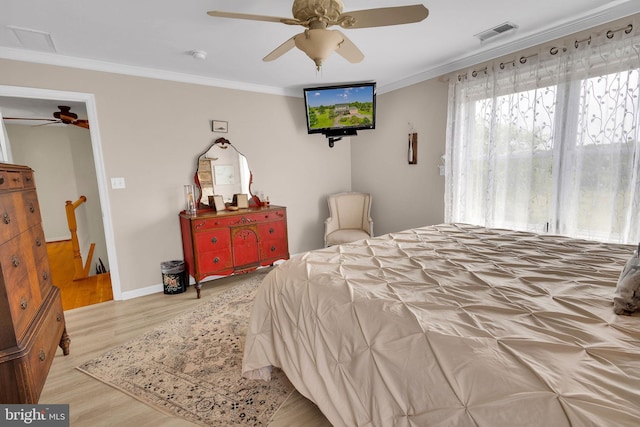 bedroom featuring light wood-type flooring, ceiling fan, and ornamental molding