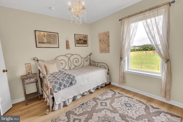 bedroom featuring hardwood / wood-style floors and a chandelier