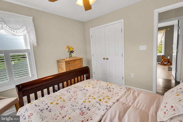 bedroom featuring a closet, multiple windows, ceiling fan, and hardwood / wood-style floors