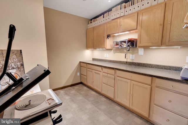 kitchen featuring light brown cabinets and lofted ceiling