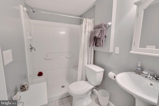 bathroom with tile patterned flooring, toilet, walk in shower, and sink