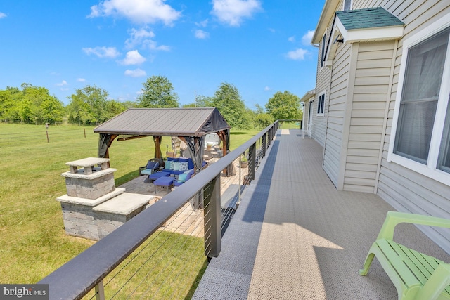 wooden deck featuring outdoor lounge area, a gazebo, and a lawn