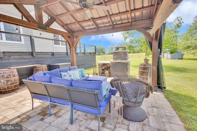 view of patio / terrace featuring a gazebo, an outdoor living space with a fireplace, and ceiling fan