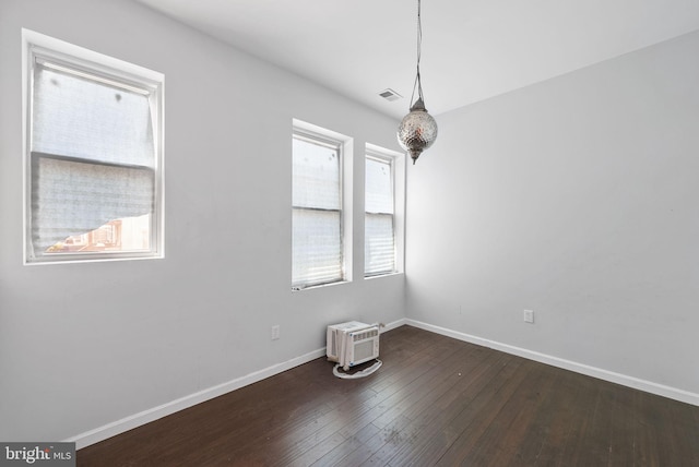 empty room with plenty of natural light and wood-type flooring