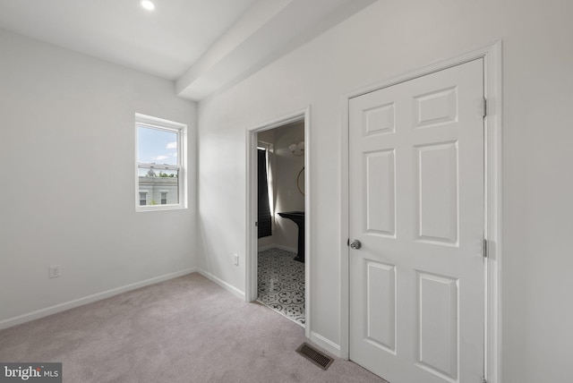 unfurnished bedroom featuring a closet and light colored carpet