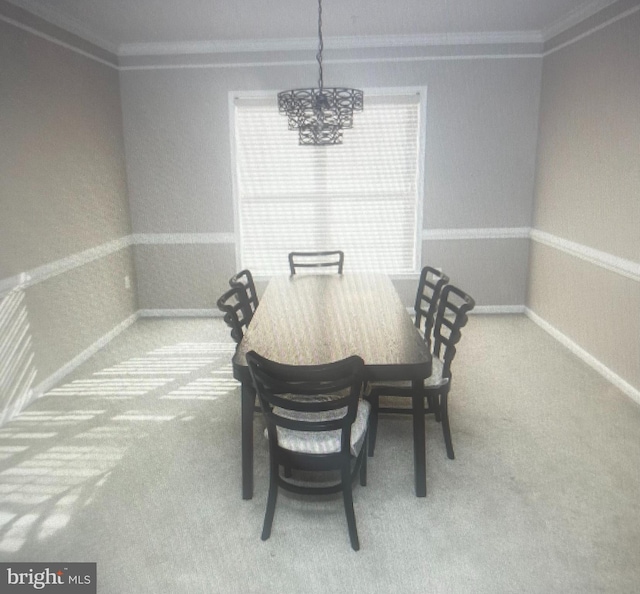 carpeted dining room with crown molding and a chandelier