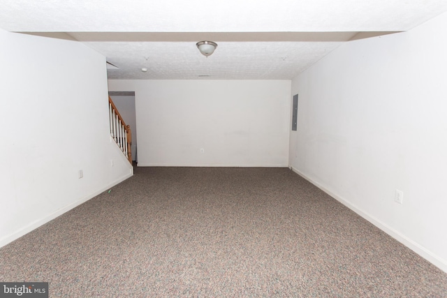 carpeted empty room with electric panel and a textured ceiling