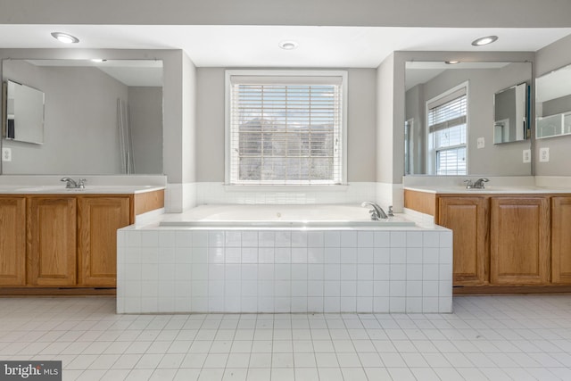 bathroom with vanity, tile patterned floors, and tiled bath