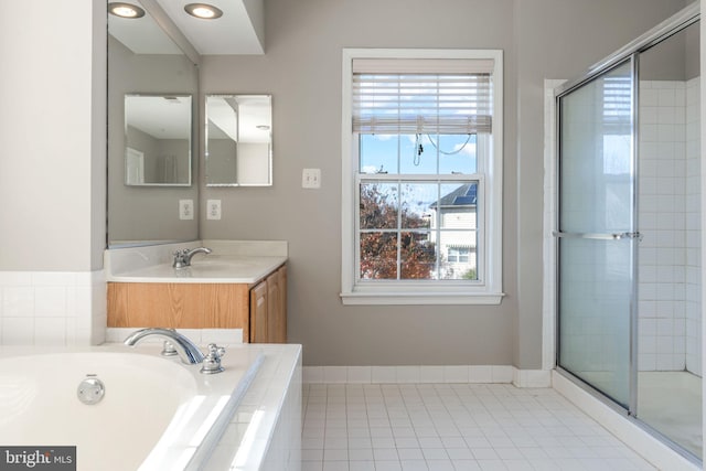 bathroom with shower with separate bathtub, a wealth of natural light, vanity, and tile patterned floors