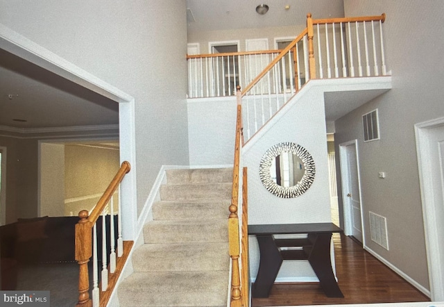 staircase featuring hardwood / wood-style flooring and crown molding