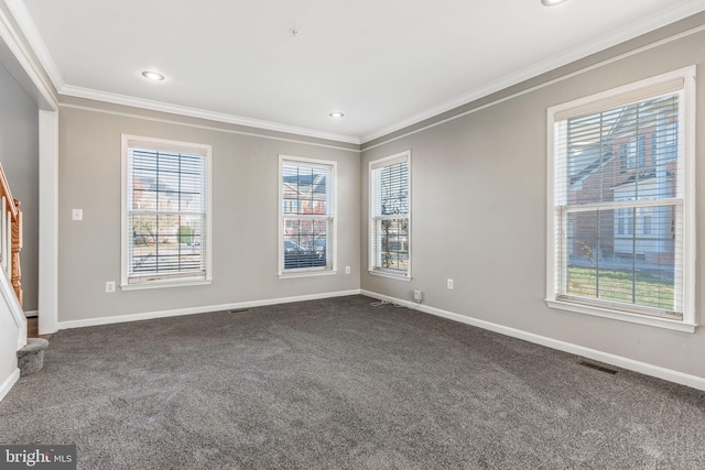 empty room with dark colored carpet, ornamental molding, and a wealth of natural light