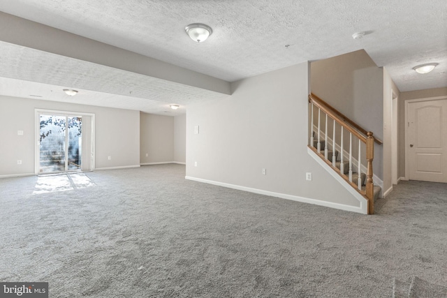 unfurnished living room with carpet flooring and a textured ceiling