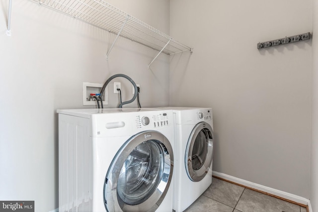 laundry room with light tile patterned floors and washer and clothes dryer