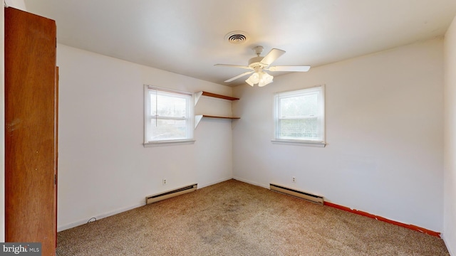 spare room featuring a baseboard radiator, light carpet, and plenty of natural light