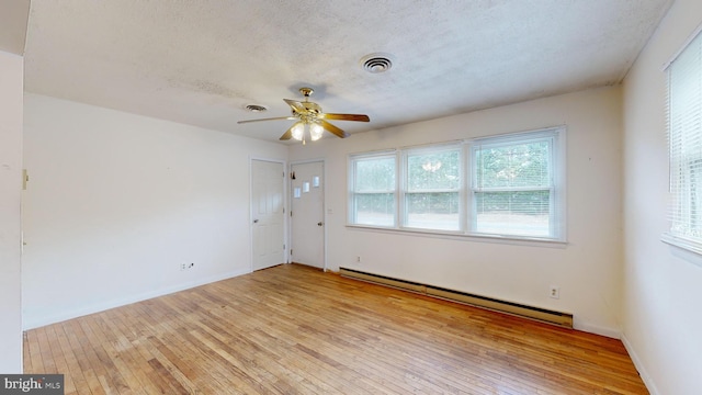 spare room featuring ceiling fan, a textured ceiling, light hardwood / wood-style floors, and a baseboard radiator