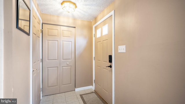 doorway to outside featuring light tile patterned floors and a textured ceiling