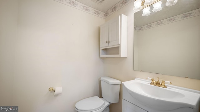 bathroom featuring a textured ceiling, vanity, and toilet