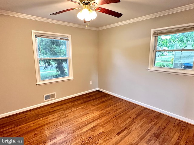 unfurnished room with ceiling fan, plenty of natural light, hardwood / wood-style floors, and crown molding