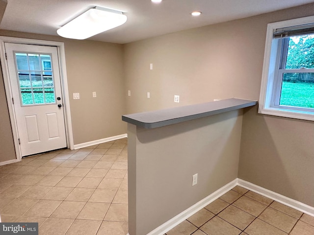 kitchen featuring kitchen peninsula, plenty of natural light, and light tile patterned floors