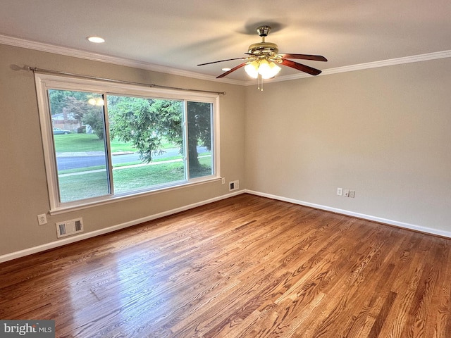 empty room with ceiling fan, hardwood / wood-style flooring, and ornamental molding