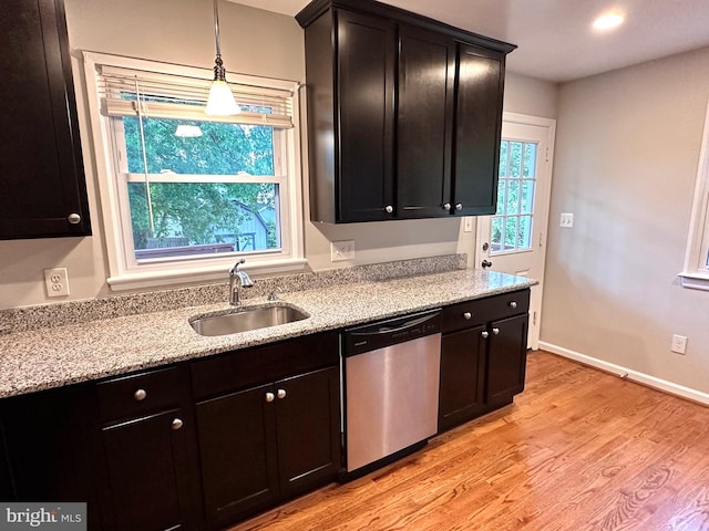 kitchen featuring sink, light hardwood / wood-style flooring, decorative light fixtures, light stone countertops, and stainless steel dishwasher