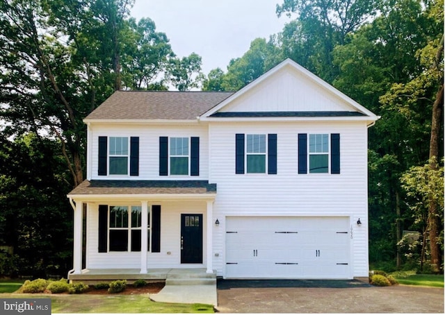 view of front of home featuring a garage, covered porch, and aphalt driveway