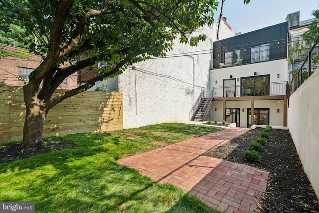 back of property with a lawn and a patio