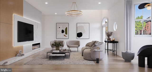 living room featuring a chandelier and light wood-type flooring