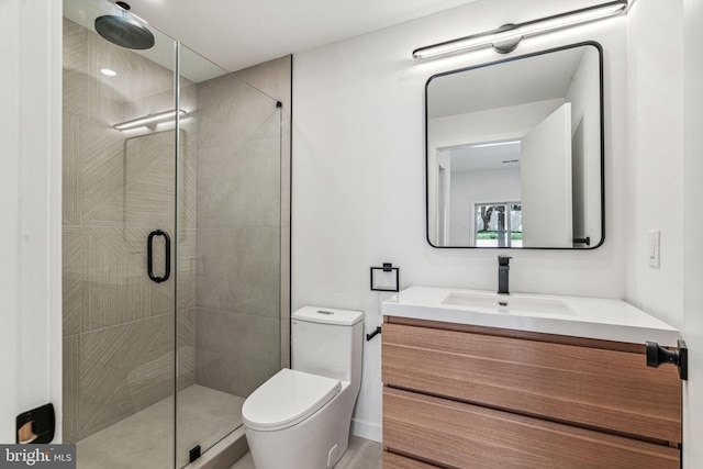 bathroom featuring vanity, toilet, and a shower with shower door