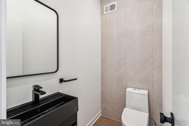 bathroom with hardwood / wood-style floors, toilet, and sink