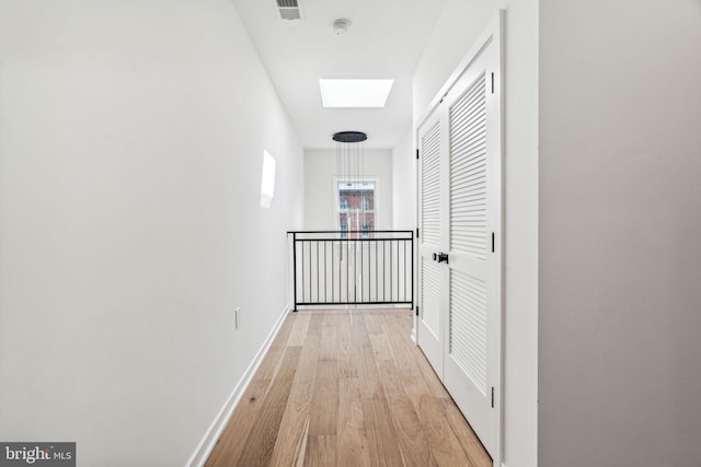 hall featuring a skylight and light wood-type flooring