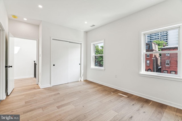 unfurnished bedroom with light hardwood / wood-style floors and a closet