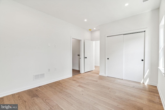 unfurnished bedroom with a closet and light hardwood / wood-style flooring