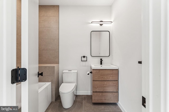 bathroom with tile patterned floors, a tub, vanity, and toilet