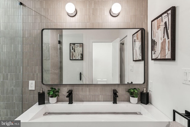 bathroom featuring vanity and tasteful backsplash