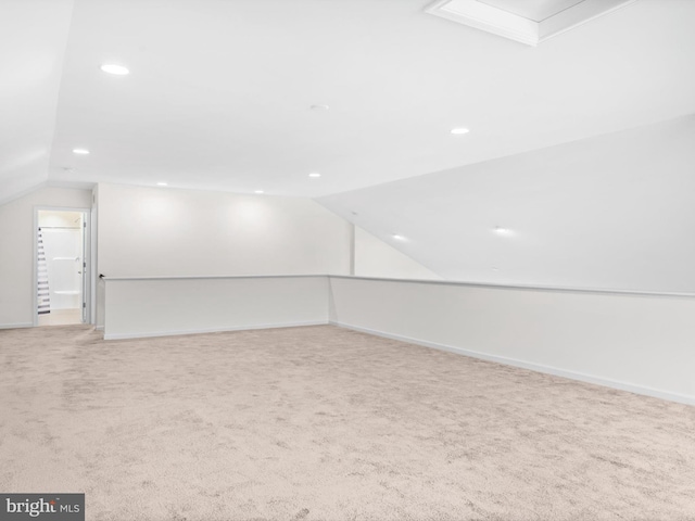 carpeted empty room with vaulted ceiling