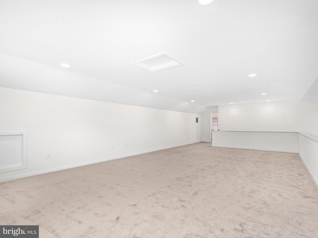 carpeted empty room with vaulted ceiling