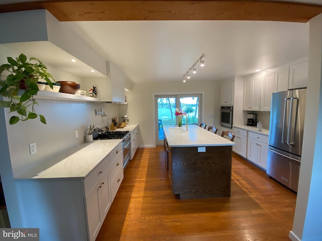 kitchen with white cabinets, high end appliances, dark hardwood / wood-style flooring, sink, and wall chimney range hood