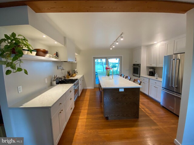 kitchen with high end appliances, dark wood-style floors, light countertops, white cabinetry, and a sink