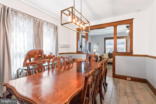 dining space featuring hardwood / wood-style flooring and ceiling fan with notable chandelier