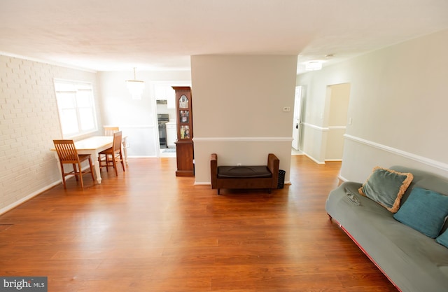 living room with wood-type flooring and brick wall