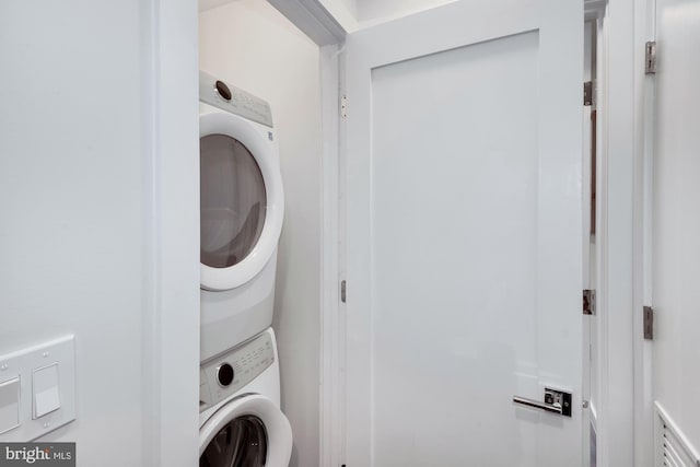 laundry area featuring stacked washer / drying machine