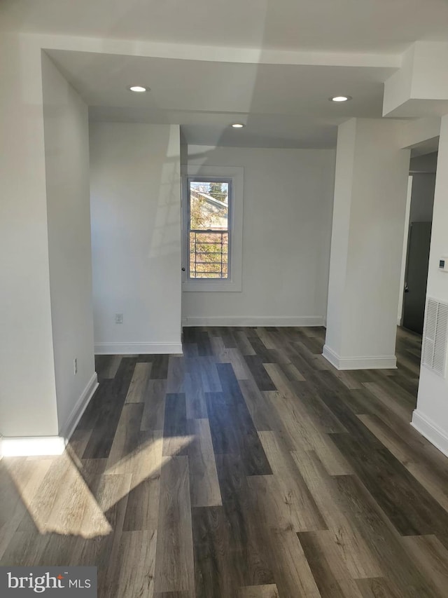 unfurnished room with dark wood-type flooring