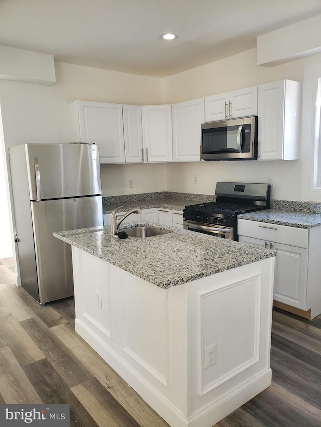 kitchen featuring sink, dark wood-type flooring, a kitchen island with sink, white cabinets, and appliances with stainless steel finishes