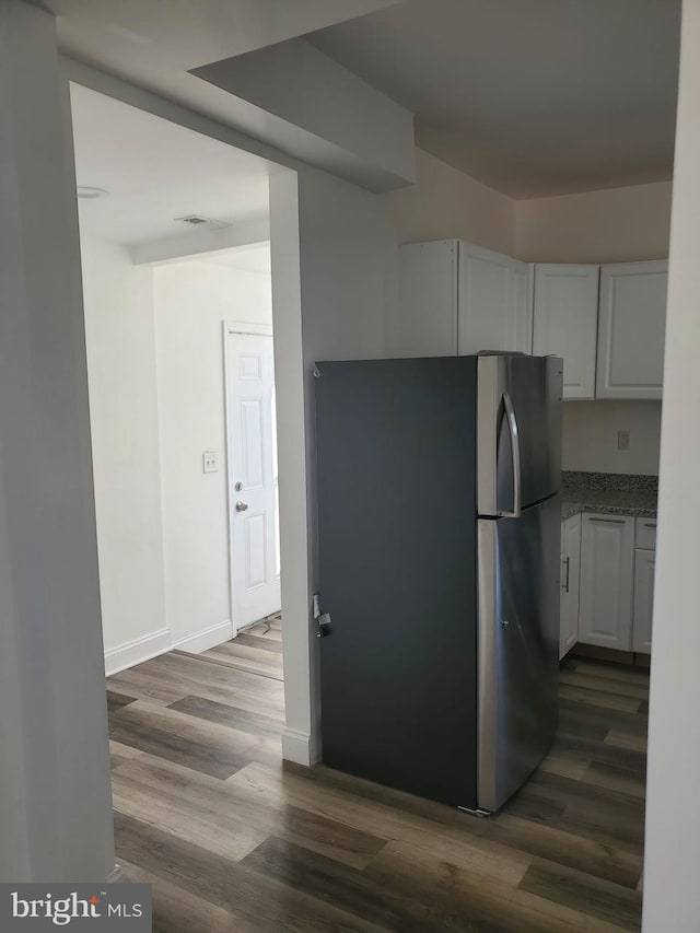 kitchen featuring stainless steel refrigerator, white cabinets, and dark hardwood / wood-style floors