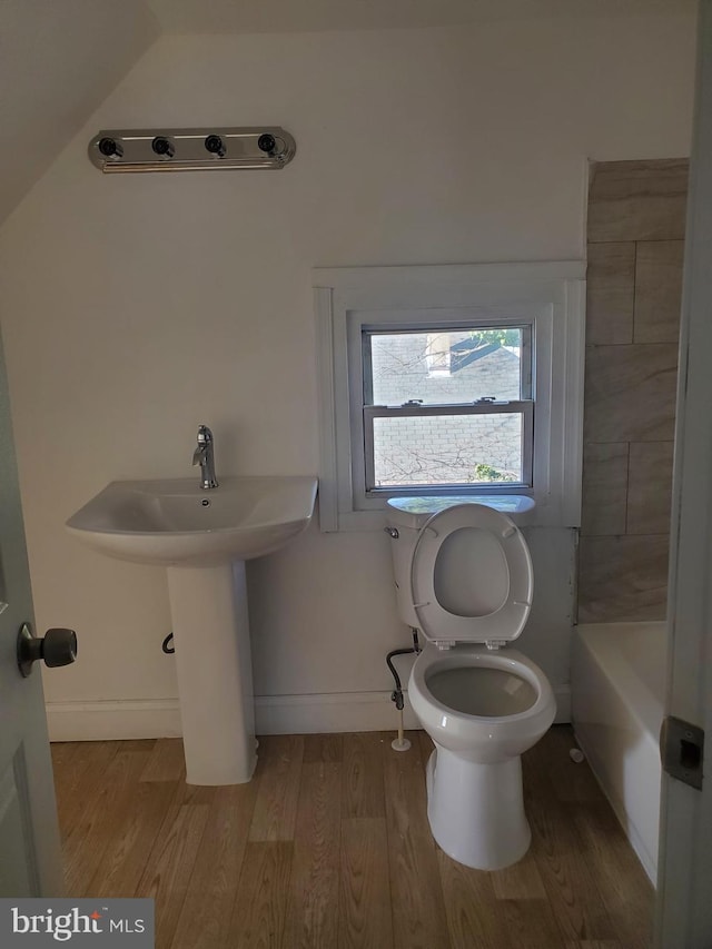 bathroom featuring hardwood / wood-style floors, toilet, and a bathtub