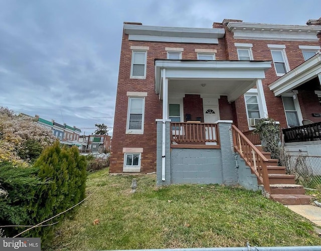 townhome / multi-family property featuring a front lawn and a porch