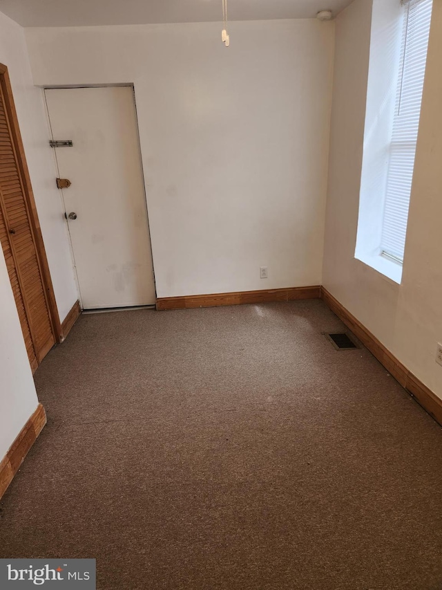 empty room featuring a wealth of natural light and carpet