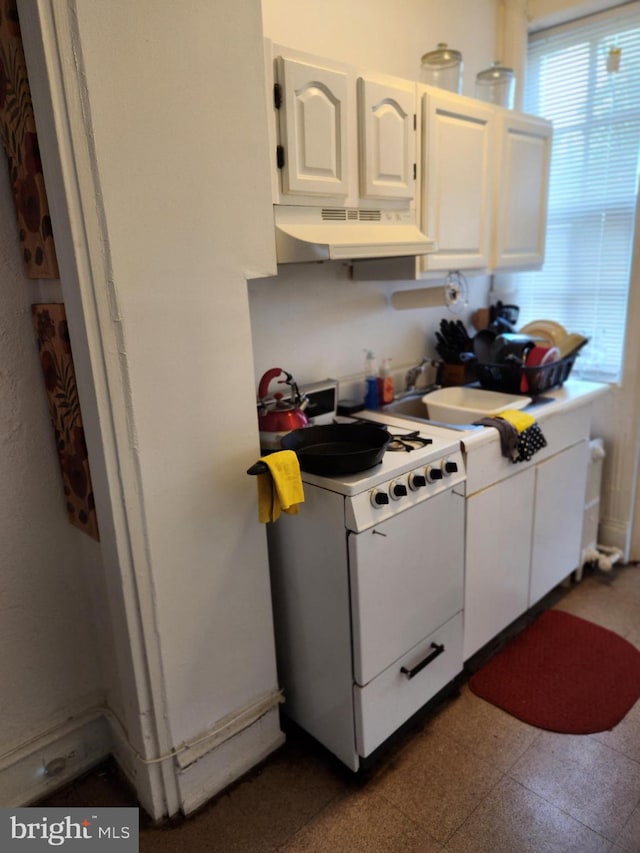 kitchen featuring white cabinets, sink, and white range with gas cooktop